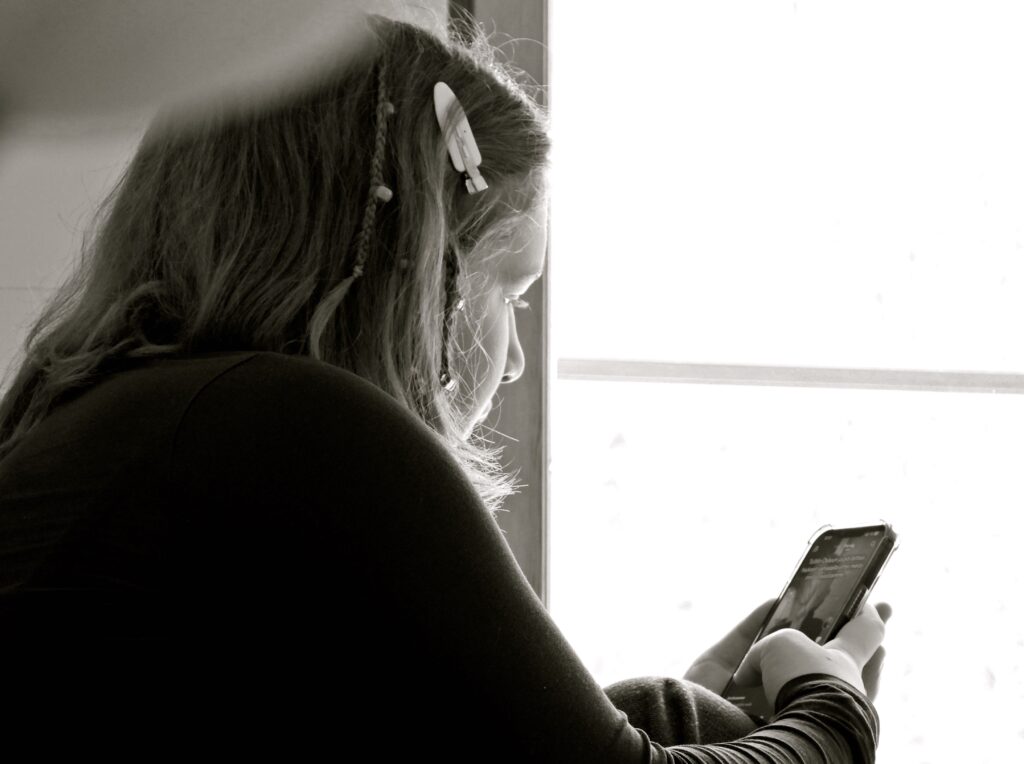 Flicka läser på sin mobil